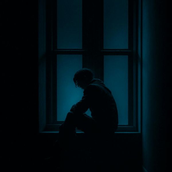 A person meditating peacefully by a window with soft light.