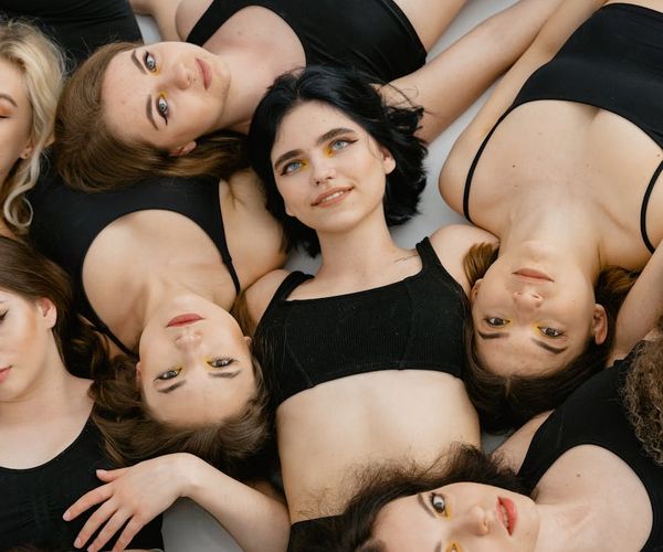 Diverse group of people smiling in a bright yoga studio setting.